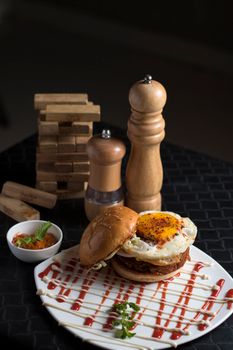 Mouth-watering burger with fried egg and gourmet sauce, ideal for lunch or dinner.