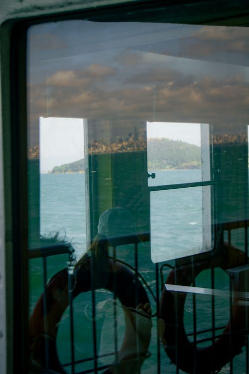 Free Reflection of a scenic coastline viewed through a ferry window with life buoys Stock Photo