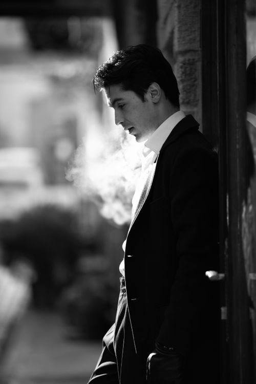 Free Black and white photo of a stylish man in Baku exhaling smoke. Stock Photo