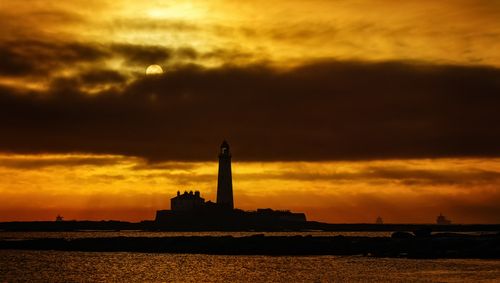 Free Silhouette of St Mary's Lighthouse against a vibrant sunset sky in England. Stock Photo