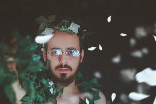 Selective Focus Photography of Man Covered With Green Vine Plant
