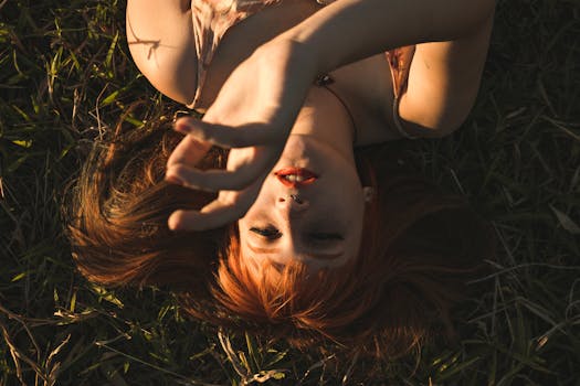 这幅艺术肖像捕捉了一位女士在温暖阳光下躺在草地上的轻松宁静时刻