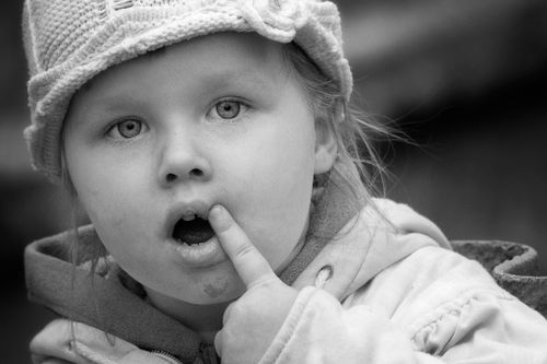 Free A captivating black and white close-up portrait of a young girl in a knitted hat. Stock Photo