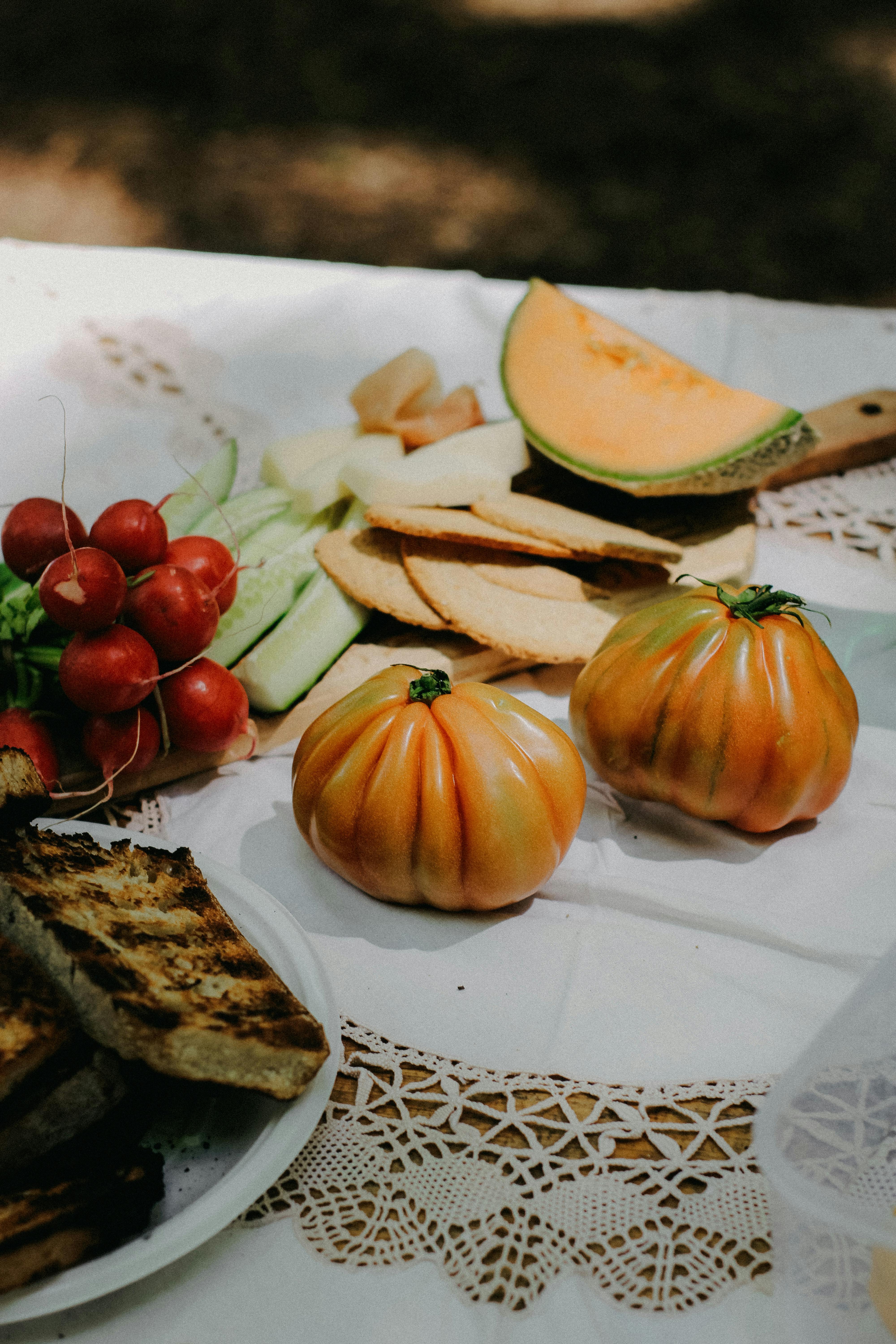 Colorful assortment of fresh vegetables on a picnic table outdoors.