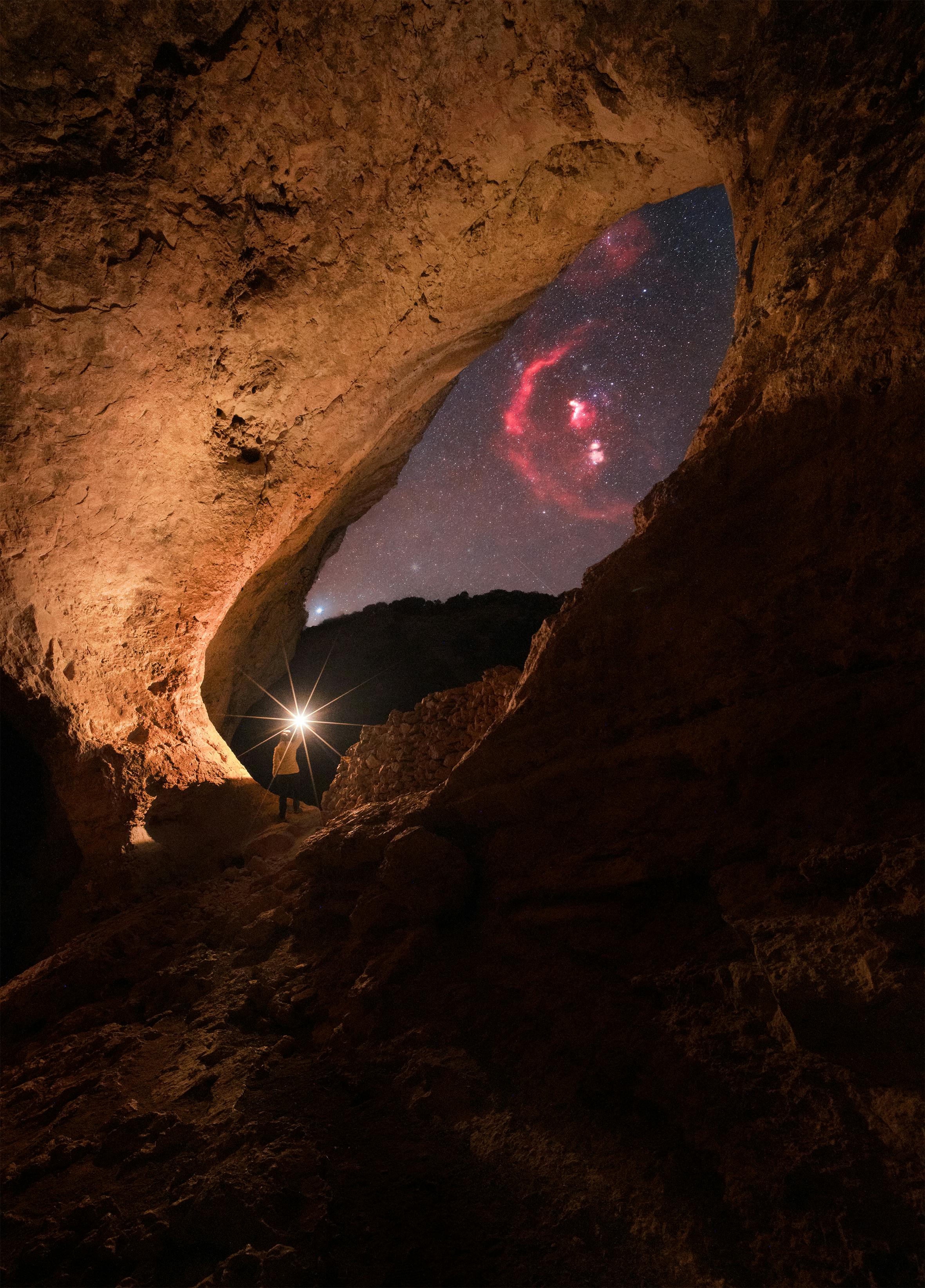 A night sky full of stars viewed through a cave opening in Guadalajara, Spain.