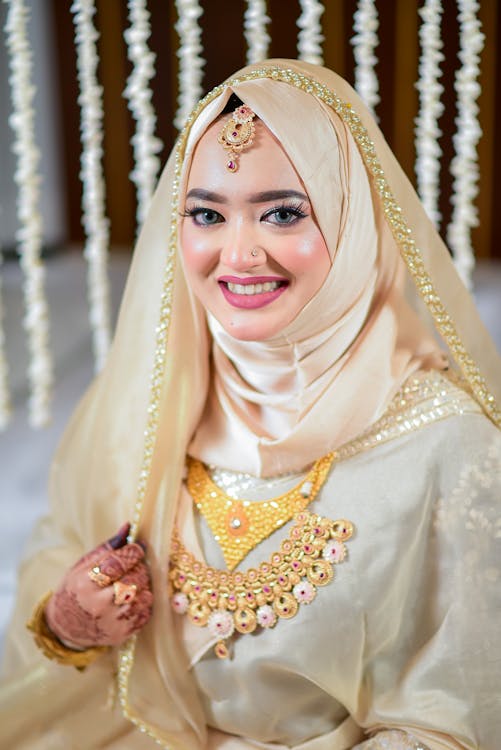 Bride in Traditional Wedding Clothing, Hijab and Veil Sitting and Smiling 