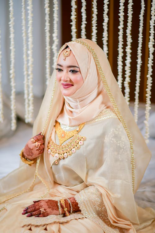 Bride in Traditional Wedding Clothing, Hijab and Veil Sitting and Smiling