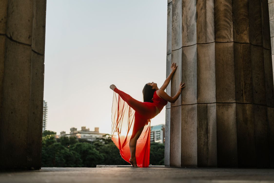 Woman in a Red Dress Dancing next to a Pillar · Free Stock Photo