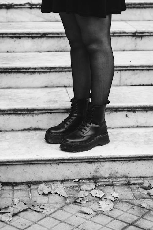 A woman in black and white standing on some stairs