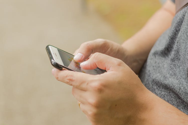 Close-up Photo Of Mans Hands Using Smartphone