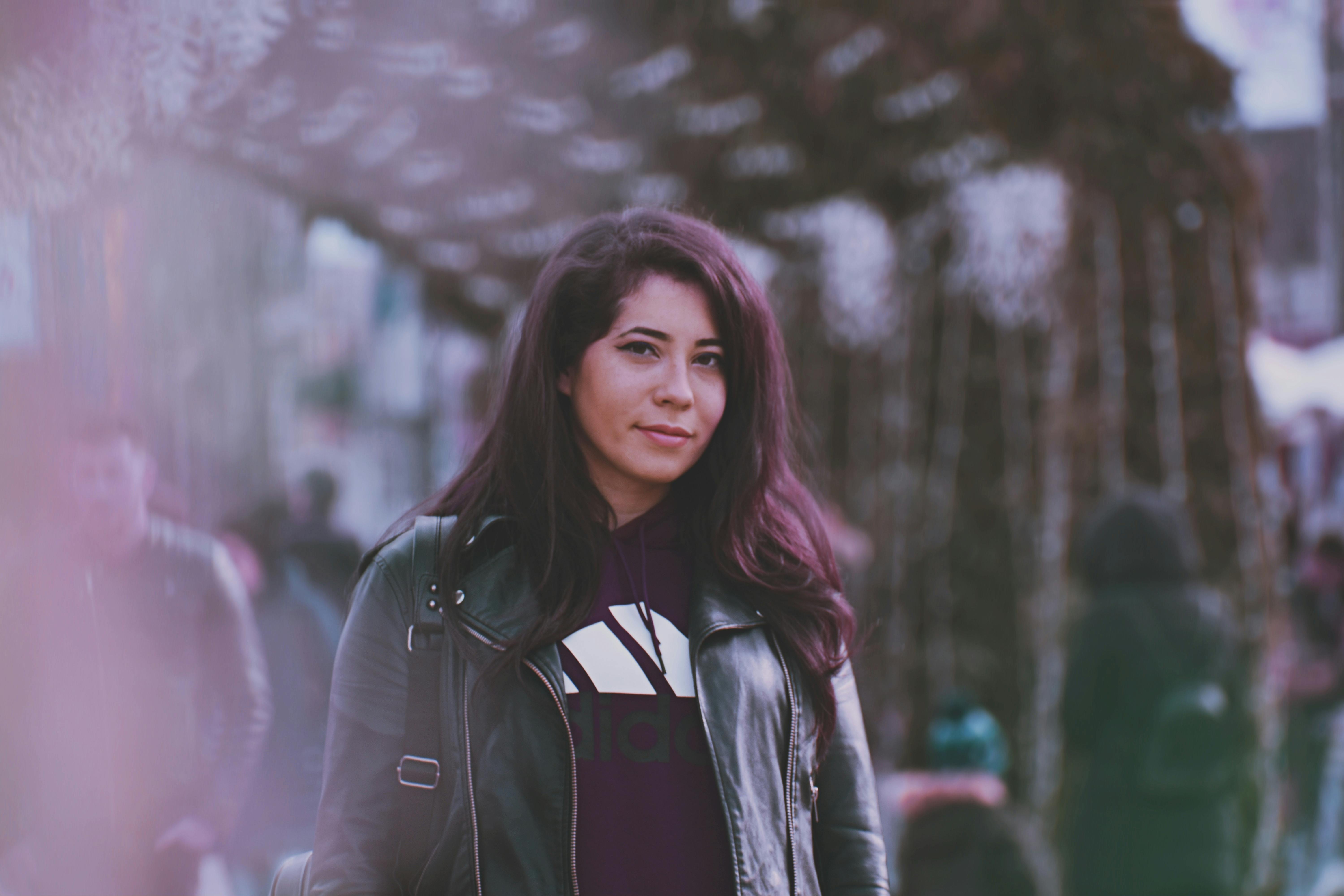 在繁忙的街道上，一位穿着皮夹克的时尚女人正在户外摆姿势