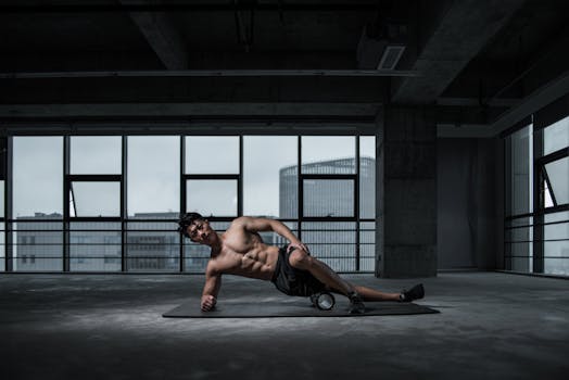 Muscular man performing yoga stretch indoors on a mat with urban window view in the background.