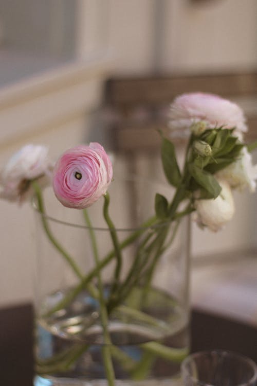 A vase with pink flowers in it on a table