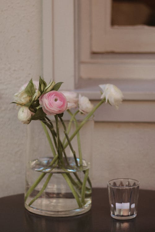A vase with pink and white flowers sitting on a table