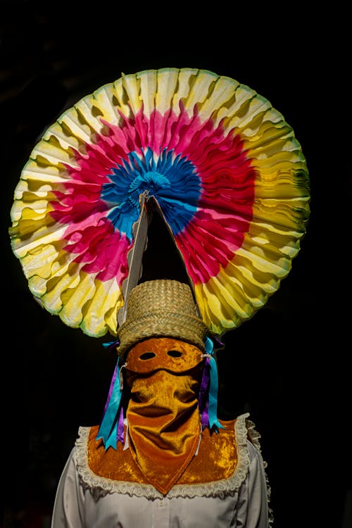 A woman wearing a colorful hat and mask