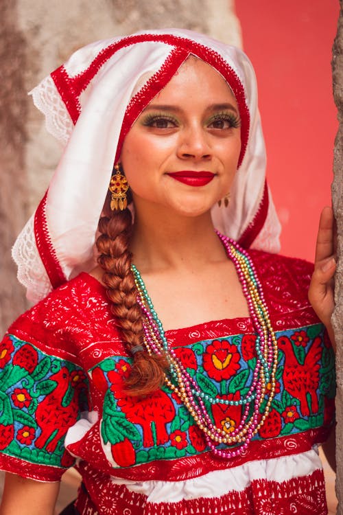 A woman in traditional mexican clothing posing for a photo