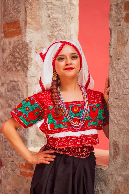 A woman in traditional mexican clothing posing for a picture