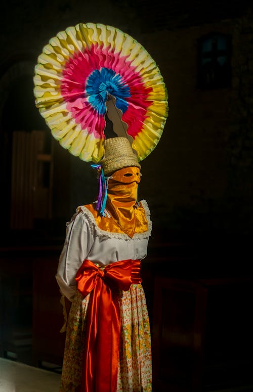 A woman in a colorful costume with a colorful umbrella