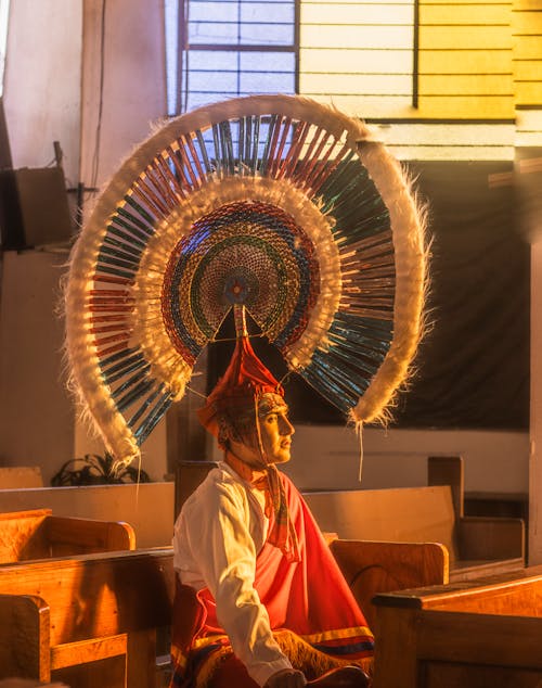 A man in a traditional costume sits in a church