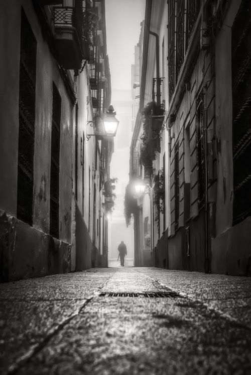 Free Mysterious black and white alleyway in Córdoba with a solitary figure walking at night. Stock Photo
