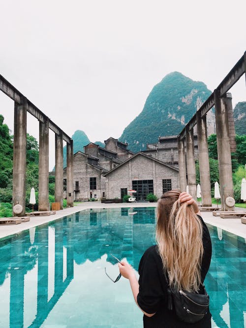 Woman Wearing Black Top Standing In Front Of Pool