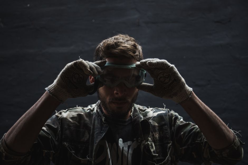 homeowner wearing protective gloves and goggles while inspecting a water heater homeowner wearing protective gloves and goggles while inspecting a water heater