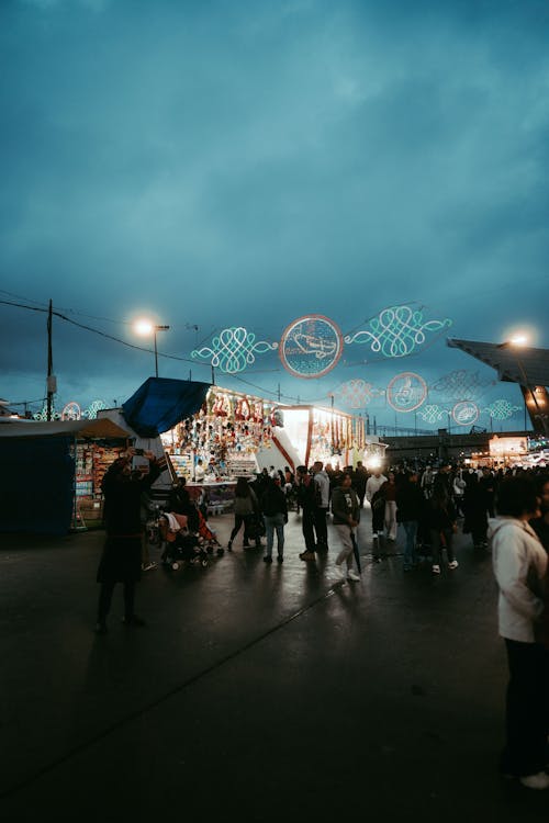 People walking around a carnival at night