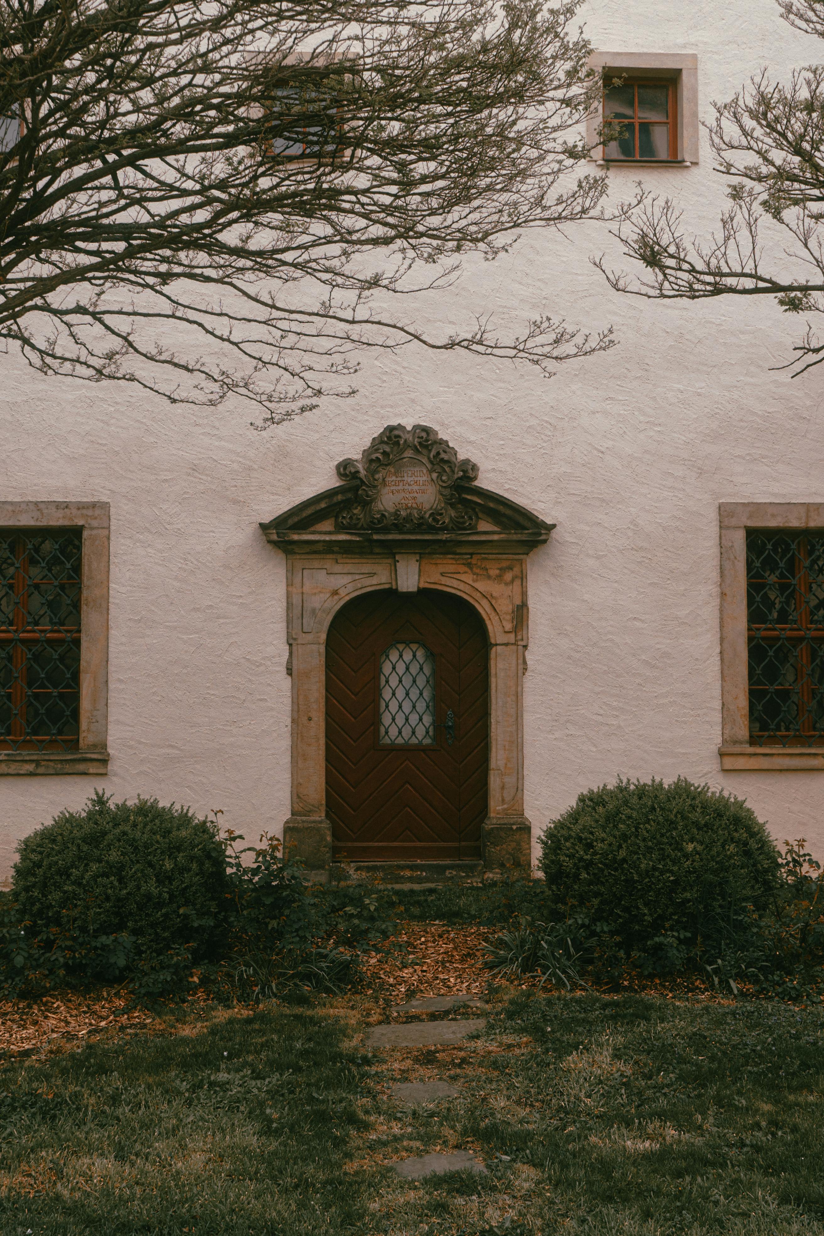 Elegant wooden door of Zittau monastery showcasing classic architectural elements and green surroundings.