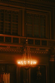 Warm lit interior featuring an antique chandelier in a historical building.