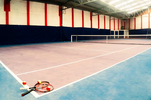 A tennis court with a net and a tennis racket