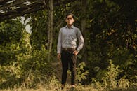 一位身着职业装的男模特在郁郁葱葱的户外环境中的肖像