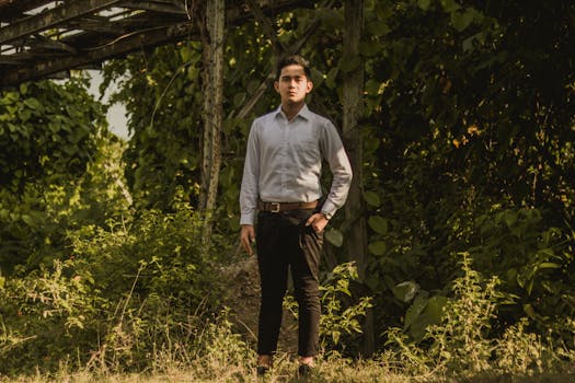 一位身着职业装的男模特在郁郁葱葱的户外环境中的肖像