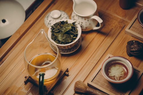 бесплатная Белый керамический чайник рядом с чашкой с листьями Стоковое фото