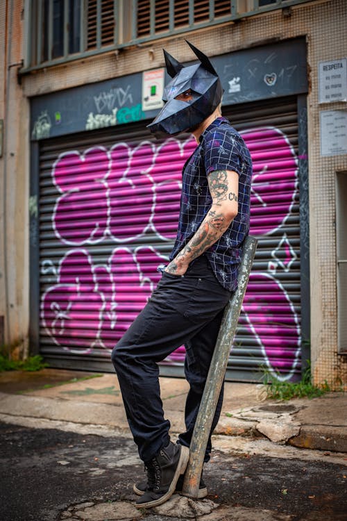 Shallow Focus Photo of Man Wearing Black Mask Standing Near Shutter Roller