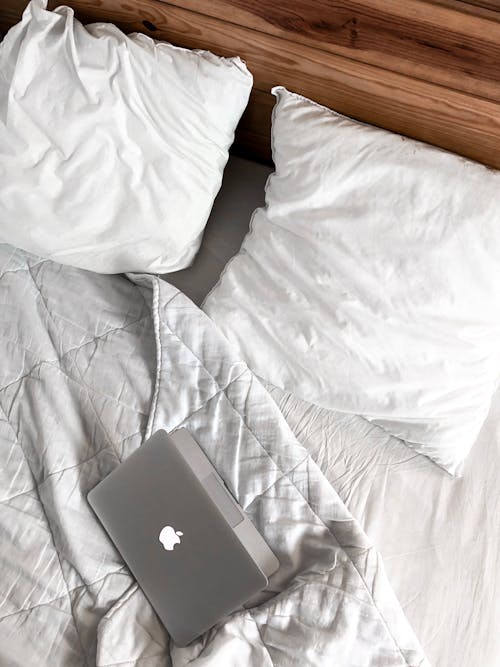 Free Macbook on a Messy Bed Stock Photo
