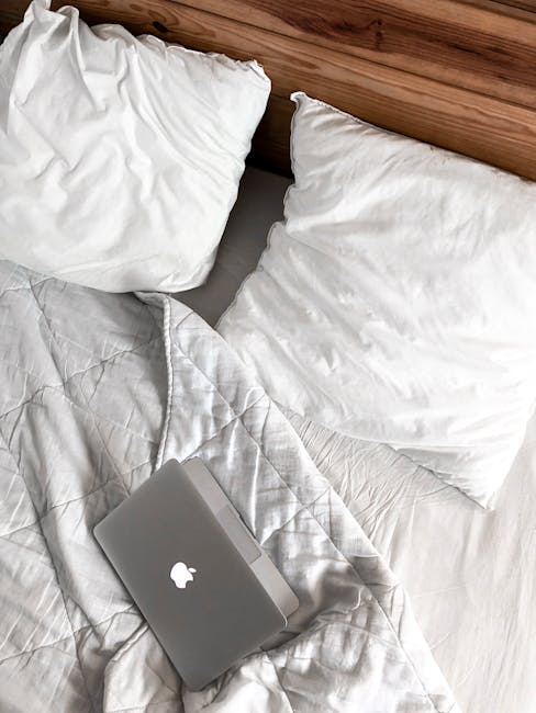 A comfortable bedroom scene with a laptop on a bed, perfect for remote work or relaxation.