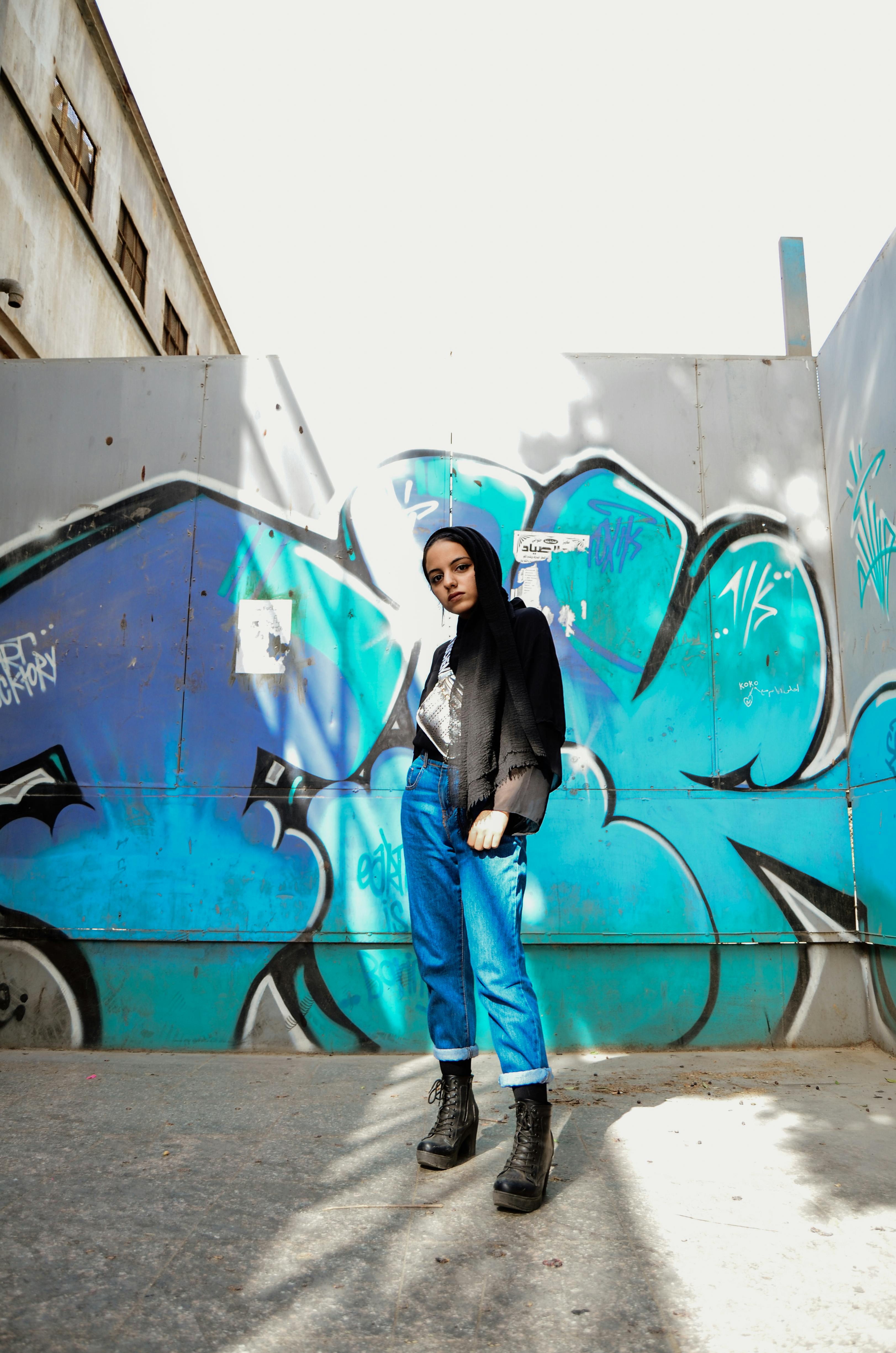 photo of woman standing in front of graffiti wall