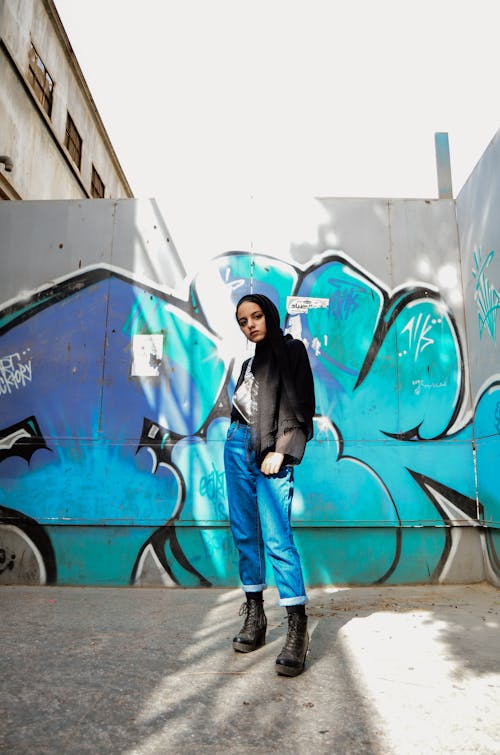 Photo of Woman Standing in Front of Graffiti Wall