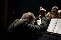 Conductor Sitting in Front of Songbook
