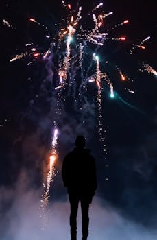 夜空中烟花绽放，映衬出一个人色彩缤纷的轮廓