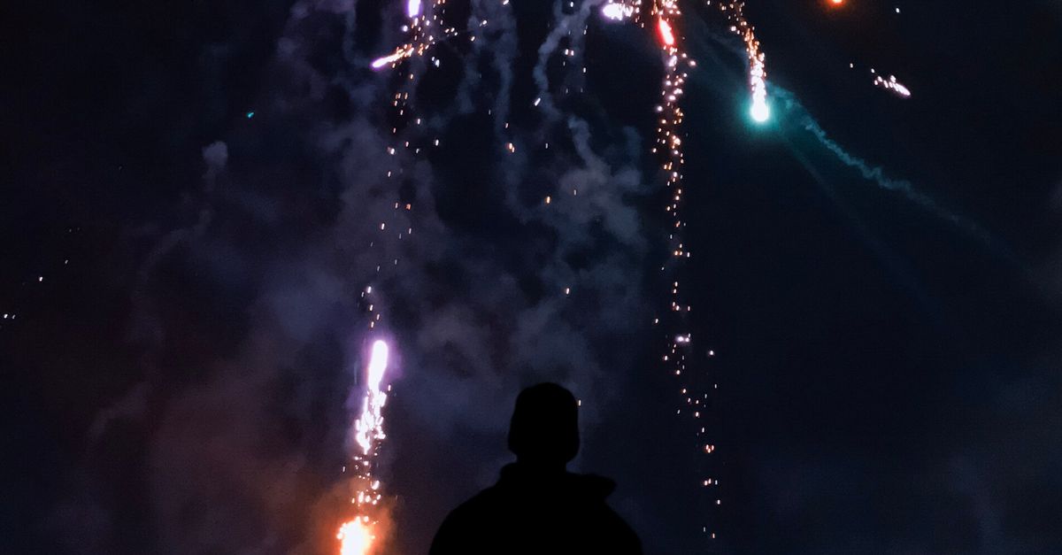 Silhouette of Person in Front of Fireworks · Free Stock Photo