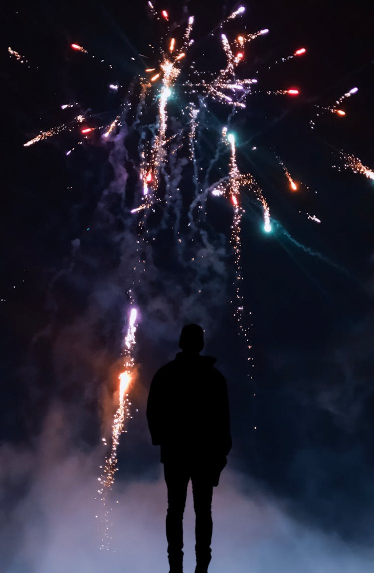 Silhouette Of Person In Front Of Fireworks