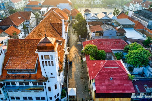在日出时分，从空中拍摄雅加达的历史建筑与红瓦屋顶，展示传统建筑风貌