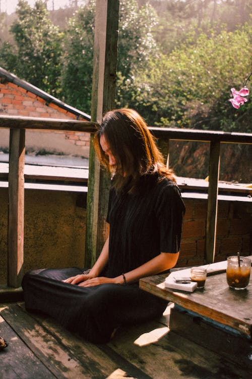 Woman Sitting on Wooden Floor