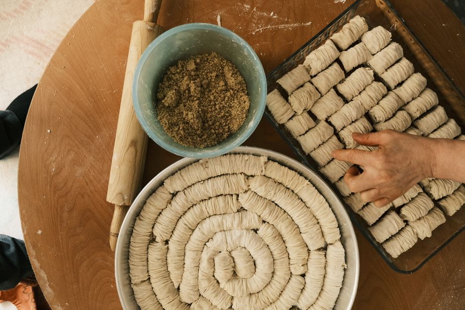 Photo by Emre Gencer on Pexels Hands preparing dough for pastries on a wooden table. - Photo by Emre Gencer on Pexels