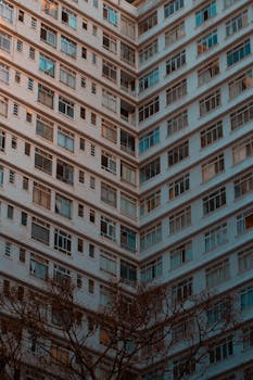 从低角度拍摄的、带有玻璃窗和现代建筑设计的高大建筑外观