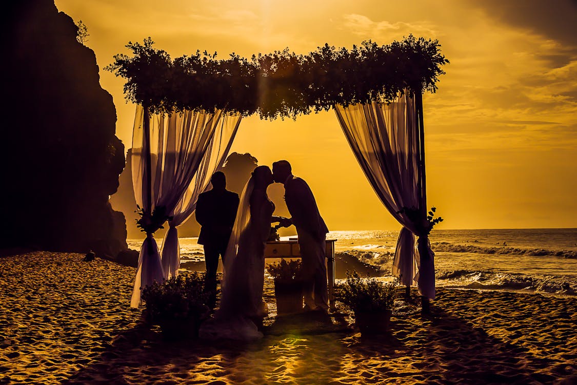 Free Silhouette Photography of Newly Wed Kissing on Seashore Stock Photo