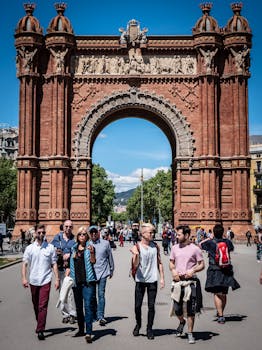 People enjoying a sunny day at the iconic Arc de Triomf in Barcelona, a famous historical landmark.