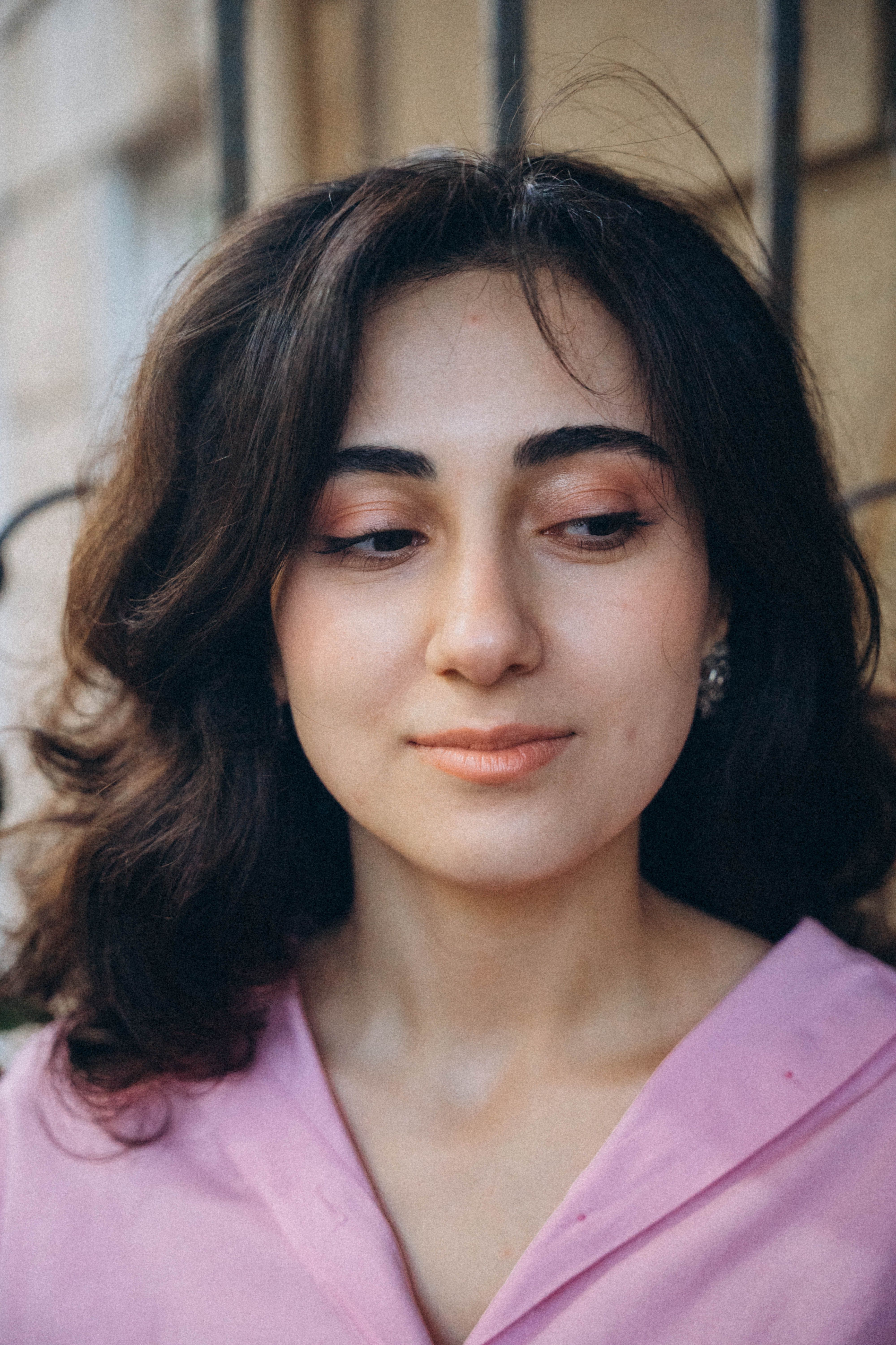 Youthful portrait of a woman in a pink shirt, captured in Baku, Azerbaijan.