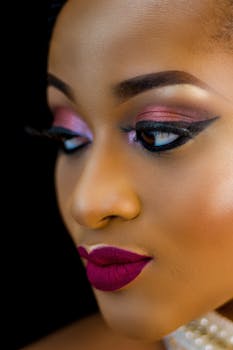Elegant close-up portrait of a woman with dramatic makeup and lush lipstick.